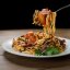 Куриные спагетти с пряными колбасками и чипсами из бекона