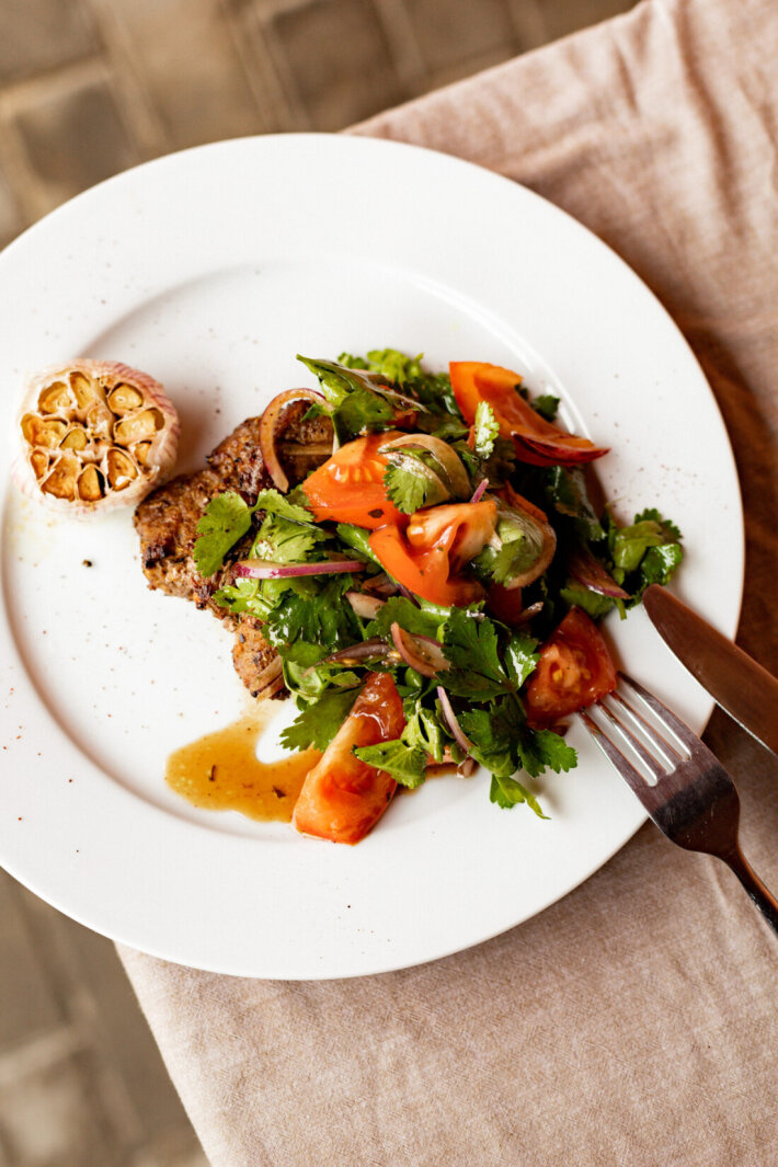 Стейк из свиной шеи с  салатом из томатов