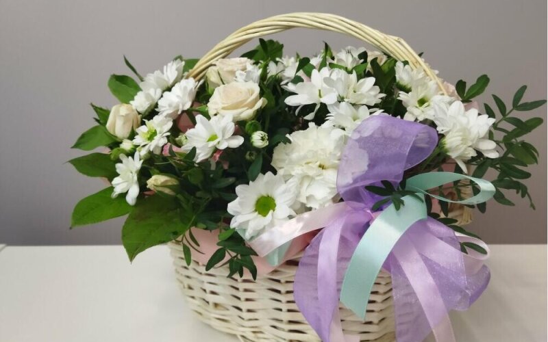 Композиция в корзине из ромашек и белых роз с дополнением гвоздики и фисташки