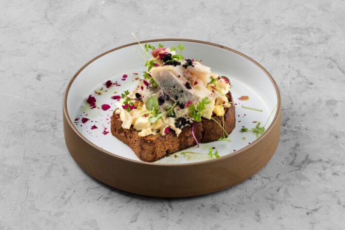 Луста на тёмном хлебе с сельдью, яичным салатом и вяленой свеклой