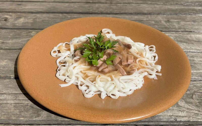 Кусочки говядины в пряном соусе с оливками с рисовой лапшой