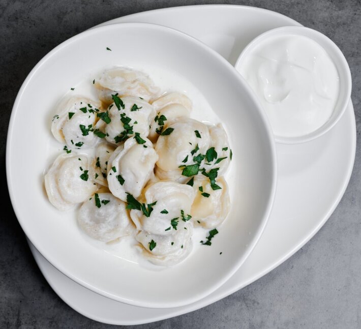 Пельмени с соусом бешамель и сметаной