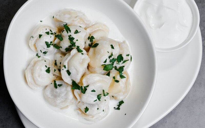 Пельмени с соусом бешамель и сметаной