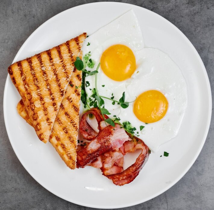Завтрак яичница с беконом и тостами