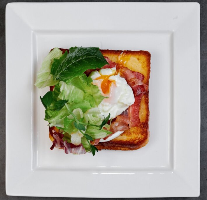 Завтрак французский тост с беконом, сыром и яйцом пашот