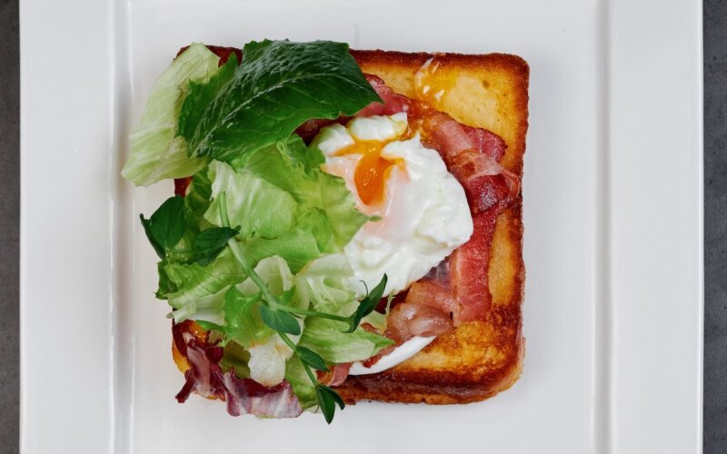 Завтрак французский тост с беконом, сыром и яйцом пашот