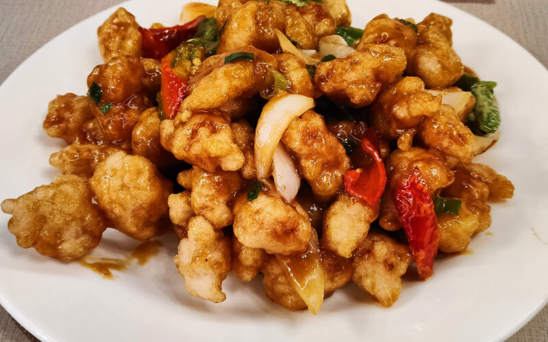 Жареные кусочки свинины в кисло-сладком соусе с зелёным перцем