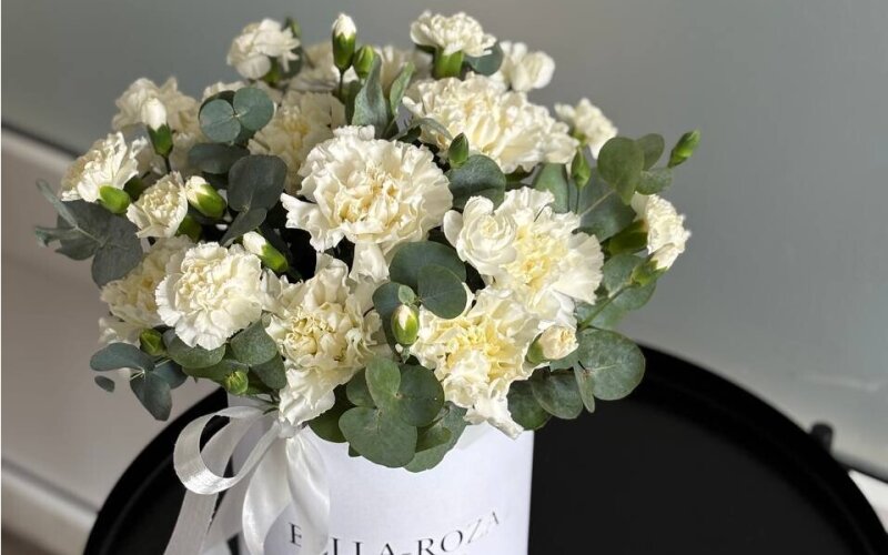 Композиция в шляпной коробке из диантусов и эвкалипта