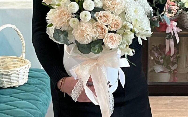 Кремовая композиция в шляпной коробке с диантусами, кустовой пионовидной розой Софи, стойкой хризантемой и альстромерией