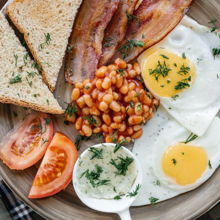 Глазунья из двух яиц с обжаренным беконом, помидорами, тостами с зелёным маслом