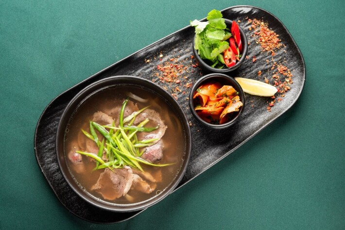 Бульон с говядиной, рисовой лапшой и зеленью